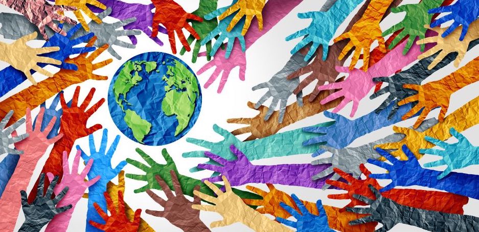 hands of every color reach towards a map of the earth